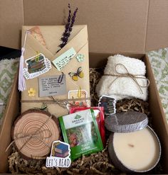 a box filled with lots of crafting items on top of a bed next to a candle