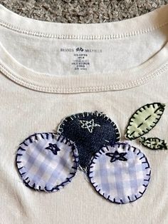 three appliques on the back of a white t - shirt with blue gingham