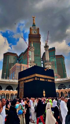 many people are gathered around the kabab in front of some tall buildings under cloudy skies