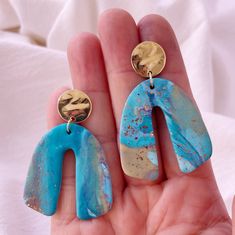 Blending the beauty of turquoise waters with sandy beaches. These arch earrings are the perfect size to for a beach outfit or pair with anything. Available in blue and sand with speckled designs. A must-have for every beach enthusiast.  Our turquoise Waters Earrings are handcrafted in polymer clay and fired to create a beautiful piece that will last for years. The lightweight design adds a mix of fun and funk, with a twist. SPECS: Do you want to stand out from the crowd?  Wear these fun animal e Artsy Turquoise Nickel-free Earrings, Artsy Nickel-free Turquoise Earrings, Hand Painted Turquoise Drop Earrings, Turquoise Resin Drop Earrings, Blue Resin Teardrop Earrings, Handmade Blue Resin Earrings, Artsy Blue Dangle Earrings, Turquoise Hand Painted Teardrop Earrings, Turquoise Teardrop Hand Painted Earrings