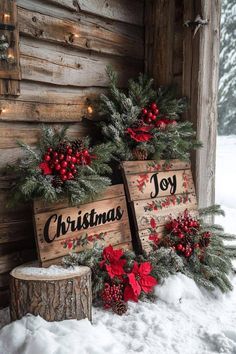 two wooden christmas signs sitting on top of snow covered ground