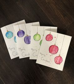 four christmas cards with watercolor ornaments on them