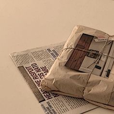 a newspaper with a piece of paper wrapped in brown paper and tied up to it