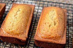 four loafs of banana bread cooling on a wire rack in the oven, with one cut off