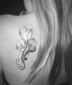 a woman with a flower tattoo on her back shoulder