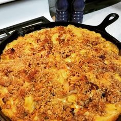 a casserole dish with cheese and meat in it sitting on a stove top