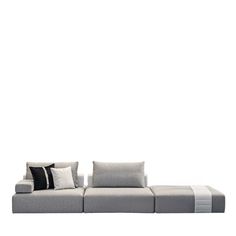 a couch with pillows on it sitting in front of a white wall