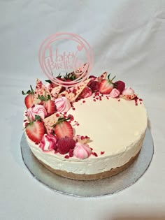 a birthday cake with strawberries and pink frosting