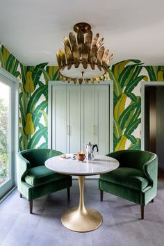 a dining room with green chairs and a white table