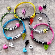 four bracelets with words and smiley faces on them sitting on a table next to each other