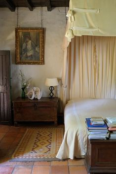 a bed sitting next to a dresser in a bedroom on top of a tiled floor