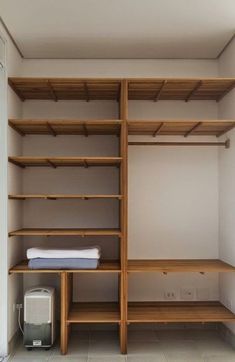 an empty walk in closet with wooden shelves