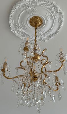 a chandelier hanging from the ceiling in a room with white walls and ceilings