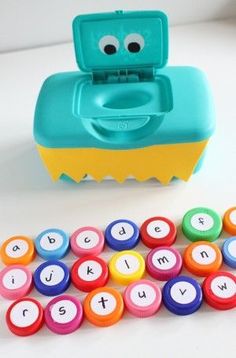 a cup of coffee next to a toy with letters on it and a game set