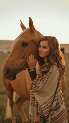 a woman standing next to a brown horse