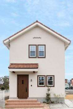 a white house with brown trim and two windows