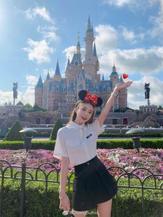 a woman in a mickey mouse hat poses for a photo at the disneyland world theme park