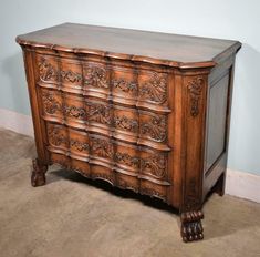 an old wooden dresser with ornate carvings on the front and sides, in a room