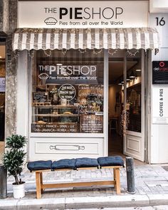 a store front with a bench in front of it