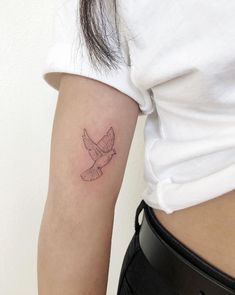 a small bird tattoo on the right arm and lower half of the arm is shown