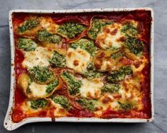 a square casserole dish with broccoli, cheese and sauce in it