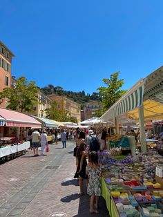 many people are shopping at an outdoor market