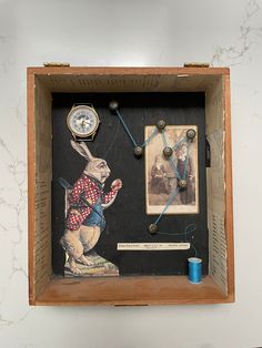 a wooden box with an image of a rabbit holding a fishing rod and two clocks on the wall