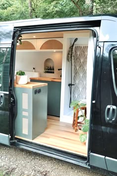 a van with its door open to show the kitchen and living area inside it's interior