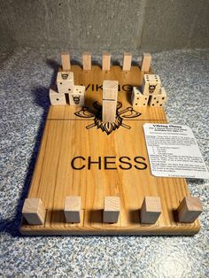 a wooden board game with dices on it and the word chess written in black