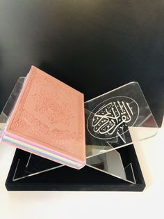 two books sitting on top of each other in front of a black desk with a white background