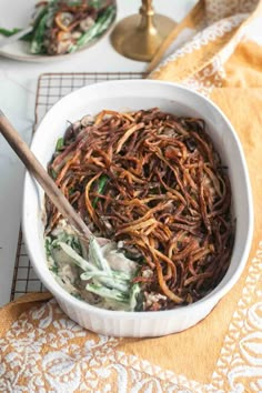 a white bowl filled with noodles on top of a table