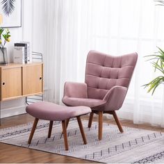 a pink chair and footstool in front of a window