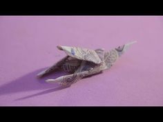 an origami bird on a pink background