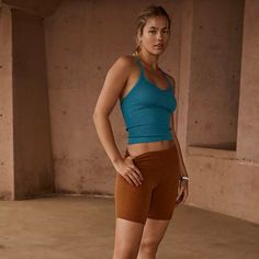 a young woman is posing for the camera in her sports bra top and short shorts