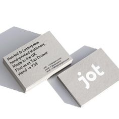 two business cards sitting next to each other on top of a white surface with the word jot printed on it