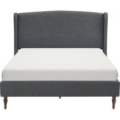 a bed with a gray headboard and white sheets on it's bottom half