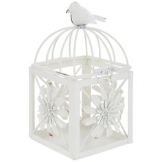 a white bird sitting on top of a cage with flowers in the front and bottom