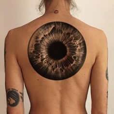 a man with an eyeball tattoo on his back