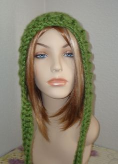 a mannequin head wearing a green knitted hat on top of a table