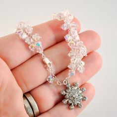 This wedding bracelet has serious sparkle. It is made with over 75 genuine Swarovski crystals, linked together to form a long cluster. The crystals are clear, with an aurora borealis, or AB, coating. This coating reflects the colours all around the crystals - a very pretty effect. It reminds me of the sun glinting off the snow and frost on a winter morning. I have used sterling silver components throughout, including a petite lobster clasp to secure the bracelet. This bracelet has a bit of we... White Crystal Bracelet With Bling, Crystal Bling Bracelet For Gift, White Crystal Bracelet With Sparkling Stones, Sparkling Crystal Bracelet For Anniversary, Crystal Bracelet Gift, White Sparkling Crystal Bracelets, Sparkling Crystal Wedding Bracelet, Handmade Blue Crystal Wedding Bracelet, Elegant Adjustable Crystal Bracelet, Nickel Free