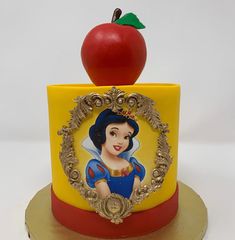 there is a cake that has an apple on top of it with snow white's face