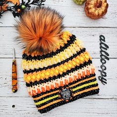 an orange and black striped knitted hat next to a pair of scissors