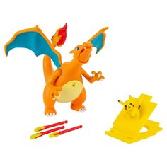 an orange and blue toy is next to some yellow markers on a white background with a red toothbrush in the foreground