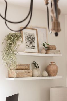 shelves with books, vases and pictures on them in a home office area or dining room