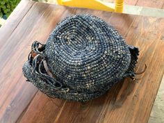 a woven bag sitting on top of a wooden table