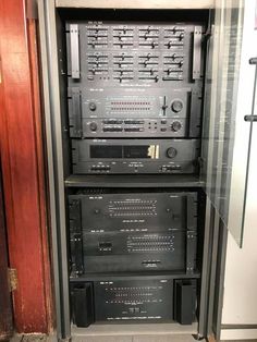 an array of electronic equipment in a room next to a door with glass panels on it