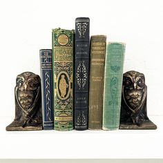 an owl figurine sitting on top of three books in front of each other