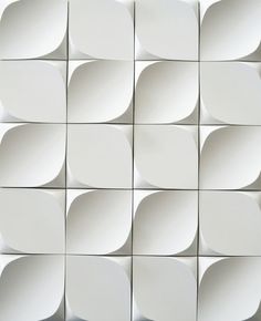 a white wall with many square shapes on it's sides and one in the middle