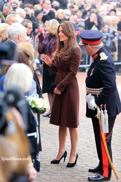 the queen and prince are talking to each other in front of a large group of people