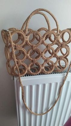 a woven purse sitting on top of a radiator